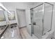 Well-lit bathroom showcasing vanity with granite countertop, a glass-enclosed shower, and tiled flooring at 4407 Lake Trudy Dr, St Cloud, FL 34769