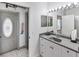 Well-lit bathroom featuring a grey vanity, mirror, and white cabinets at 4407 Lake Trudy Dr, St Cloud, FL 34769