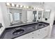 Bright bathroom featuring double sinks, ample cabinet space, and a large mirror with Hollywood-style lighting at 4407 Lake Trudy Dr, St Cloud, FL 34769