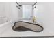Unique sunken tub with black and white tiling, a shower, and a frosted window for natural light at 4407 Lake Trudy Dr, St Cloud, FL 34769
