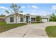 Charming single-story home featuring a teal front door, attached garage, and manicured landscaping at 4407 Lake Trudy Dr, St Cloud, FL 34769