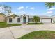 Charming single-story home featuring a teal front door, attached garage, and well-manicured landscaping at 4407 Lake Trudy Dr, St Cloud, FL 34769