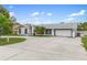 Single-story home featuring a teal front door, attached garage, and wide driveway at 4407 Lake Trudy Dr, St Cloud, FL 34769