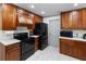 Kitchen featuring dark appliances, wood cabinets, and tile flooring at 4407 Lake Trudy Dr, St Cloud, FL 34769