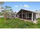View of backyard with large screened patio, garden shed, white fencing, and green grass at 4407 Lake Trudy Dr, St Cloud, FL 34769