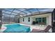 Beautiful outdoor pool area with screened-in lanai and patio seating and BBQ grill at 4504 Monado Dr, Kissimmee, FL 34746