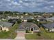 Expansive view of the neighborhood showcasing a single-story home, mature trees, and green lawns at 458 Moscato Dr, Davenport, FL 33897