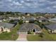 Expansive view of the neighborhood showcasing a single-story home, mature trees, and green lawns at 458 Moscato Dr, Davenport, FL 33897