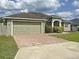 Lovely single-story home with brick driveway, two-car garage, and well-kept lawn at 458 Moscato Dr, Davenport, FL 33897