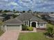 Charming single-story home with a well-manicured lawn, brick driveway, and lush landscaping at 458 Moscato Dr, Davenport, FL 33897