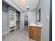 Bright bathroom featuring a vanity with double sinks, a large closet, and an open doorway leading to a shower at 5015 Nassau Cir # 4, Orlando, FL 32808