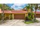Charming single-story home with a terracotta roof, lush landscaping, and a two-car garage at 5015 Nassau Cir # 4, Orlando, FL 32808