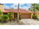 Charming single-story home with a terracotta roof, lush landscaping, and a two-car garage at 5015 Nassau Cir # 4, Orlando, FL 32808