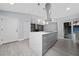 Open-concept kitchen features white cabinets, marble countertop and island with seating, and modern appliances at 5015 Nassau Cir # 4, Orlando, FL 32808