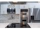 Contemporary kitchen featuring white cabinetry, stainless appliances and cooktop on white countertop at 5015 Nassau Cir # 4, Orlando, FL 32808