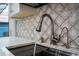 Modern kitchen with a stainless steel faucet and white marble patterned backsplash at 5015 Nassau Cir # 4, Orlando, FL 32808