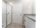 Bathroom featuring a glass shower, white tiled walls, and granite countertop with a white door at 5288 Stephs Field St, St Cloud, FL 34771