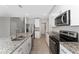 Modern kitchen with stainless steel appliances, granite countertops, island, and white cabinetry at 5288 Stephs Field St, St Cloud, FL 34771