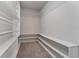 Organized walk-in closet with white shelves and carpeted floor, offering ample storage space at 5288 Stephs Field St, St Cloud, FL 34771
