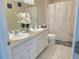 Bathroom features a double vanity, white cabinets and marble-look floors, and a shower with a stylish curtain at 585 Lucerne Blvd, Winter Haven, FL 33881