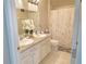 Bathroom features a double vanity, white cabinets and marble-look floors, and a shower with a stylish curtain at 585 Lucerne Blvd, Winter Haven, FL 33881
