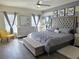 Stylish bedroom boasts a tufted headboard, modern furniture, ceiling fan and two windows for ample natural light at 585 Lucerne Blvd, Winter Haven, FL 33881