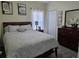 Comfortable bedroom with gray walls, a wooden bed frame, and matching wooden dresser with mirror at 585 Lucerne Blvd, Winter Haven, FL 33881