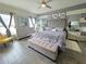 Stylish bedroom boasts a tufted headboard, modern furniture, ceiling fan and two windows for ample natural light at 585 Lucerne Blvd, Winter Haven, FL 33881