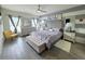 Stylish bedroom boasts a tufted headboard, modern furniture, ceiling fan and two windows for ample natural light at 585 Lucerne Blvd, Winter Haven, FL 33881