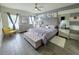 Stylish bedroom boasts a tufted headboard, modern furniture, ceiling fan and two windows for ample natural light at 585 Lucerne Blvd, Winter Haven, FL 33881