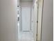 Bright hallway with neutral walls, white trim, and marble-look tile flooring provides a clean transition between rooms at 585 Lucerne Blvd, Winter Haven, FL 33881