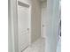 Clean hallway with neutral walls, white doors and trim, and marble-look tile flooring provides a clean transition at 585 Lucerne Blvd, Winter Haven, FL 33881