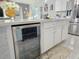 White kitchen island with a beverage fridge and marble floors at 585 Lucerne Blvd, Winter Haven, FL 33881
