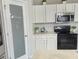Bright kitchen with pantry door, white cabinets, modern backsplash, and stainless steel appliances at 585 Lucerne Blvd, Winter Haven, FL 33881