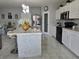Modern kitchen with white cabinets, black appliances, and a stylish mosaic-tiled island with barstool seating at 585 Lucerne Blvd, Winter Haven, FL 33881