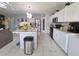 Open kitchen featuring white cabinets, stainless steel appliances, a pantry, and an island with bar seating at 585 Lucerne Blvd, Winter Haven, FL 33881
