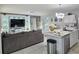 Living room boasts sleek tile floors, a custom entertainment center, and an open-concept design to the kitchen at 585 Lucerne Blvd, Winter Haven, FL 33881