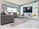 Stylish living room with a gray sectional, a glass coffee table, and a modern entertainment unit at 585 Lucerne Blvd, Winter Haven, FL 33881