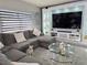 Beautiful living room with a cozy sectional sofa, a modern entertainment center, and sleek tile flooring at 585 Lucerne Blvd, Winter Haven, FL 33881