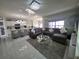 Cozy living room with a gray sectional sofa, a glass coffee table, and an open layout leading to the kitchen at 585 Lucerne Blvd, Winter Haven, FL 33881
