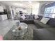 Bright living room featuring a plush sectional sofa, a glass coffee table, and an open view into the kitchen at 585 Lucerne Blvd, Winter Haven, FL 33881
