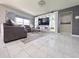 Modern living room with a gray sectional sofa, a glass coffee table, and a stylish entertainment center at 585 Lucerne Blvd, Winter Haven, FL 33881