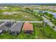 Aerial view showing two homes; one with a terracotta tile roof, the other with solar panels, in a lush, landscaped community at 605 San Augusto Dr, Kissimmee, FL 34759