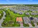 Expansive aerial view of a community with numerous homes, lakes, and lush greenery under a clear blue sky at 605 San Augusto Dr, Kissimmee, FL 34759