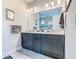 Modern bathroom with double vanity sinks, granite countertops, and a framed mirror at 605 San Augusto Dr, Kissimmee, FL 34759