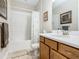 Bathroom featuring a combination bathtub and shower with white tile surround and a wooden vanity at 605 San Augusto Dr, Kissimmee, FL 34759