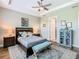 Comfortable bedroom featuring wood-look tile flooring, with tray ceilings, and views of the bathroom at 605 San Augusto Dr, Kissimmee, FL 34759