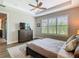 Bedroom featuring a window with plantation shutters for privacy, wood-look tile floors, and tray ceilings at 605 San Augusto Dr, Kissimmee, FL 34759