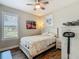 Bedroom with hardwood floors, ceiling fan, large window, and cozy white bed frame at 605 San Augusto Dr, Kissimmee, FL 34759