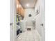 Laundry room with overhead cabinets, a white washer/dryer set, and storage shelving at 605 San Augusto Dr, Kissimmee, FL 34759